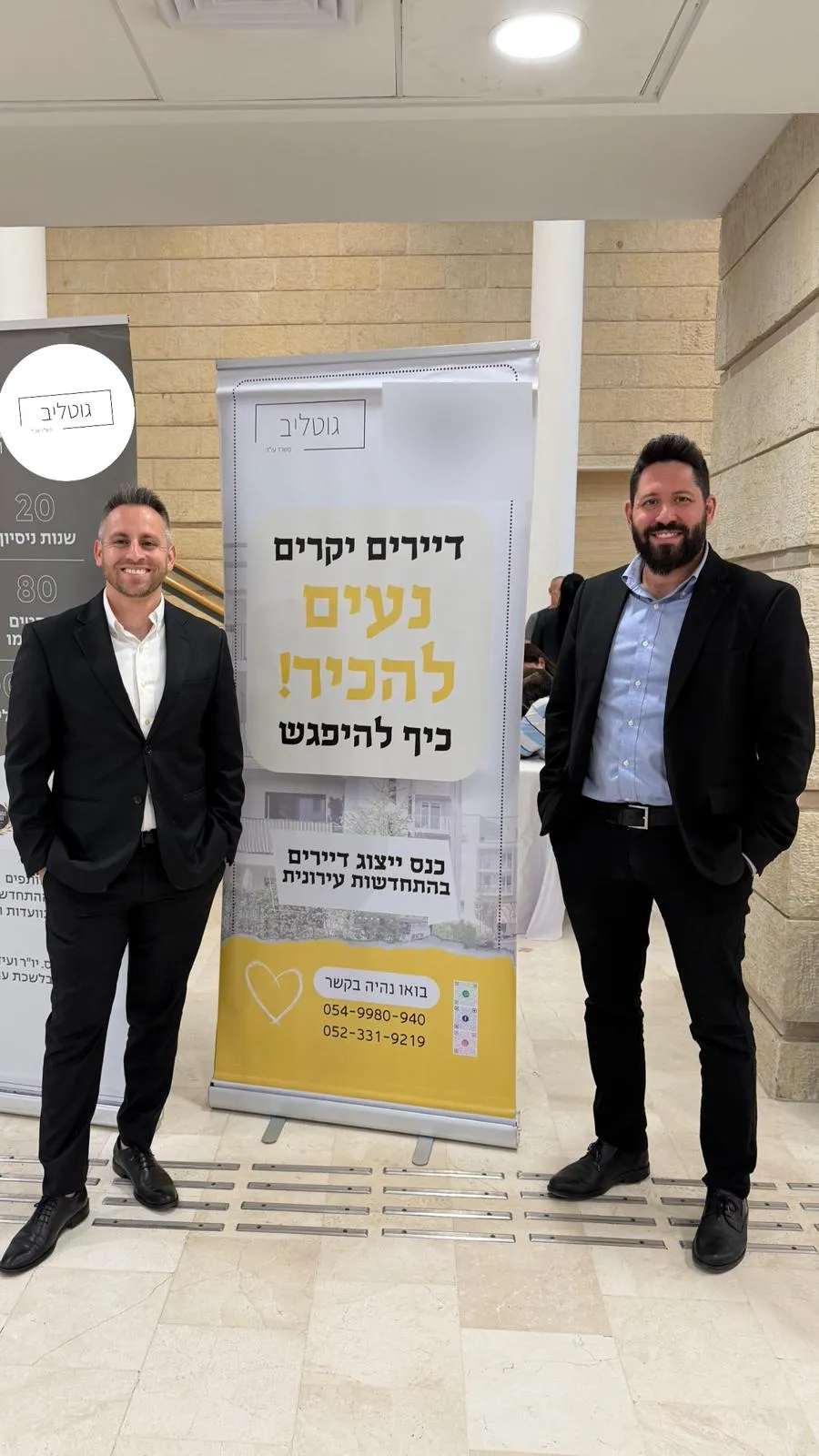הצוות ליד רול־אפ קבלת הפנים — דיירים יקרים, נעים להכיר
