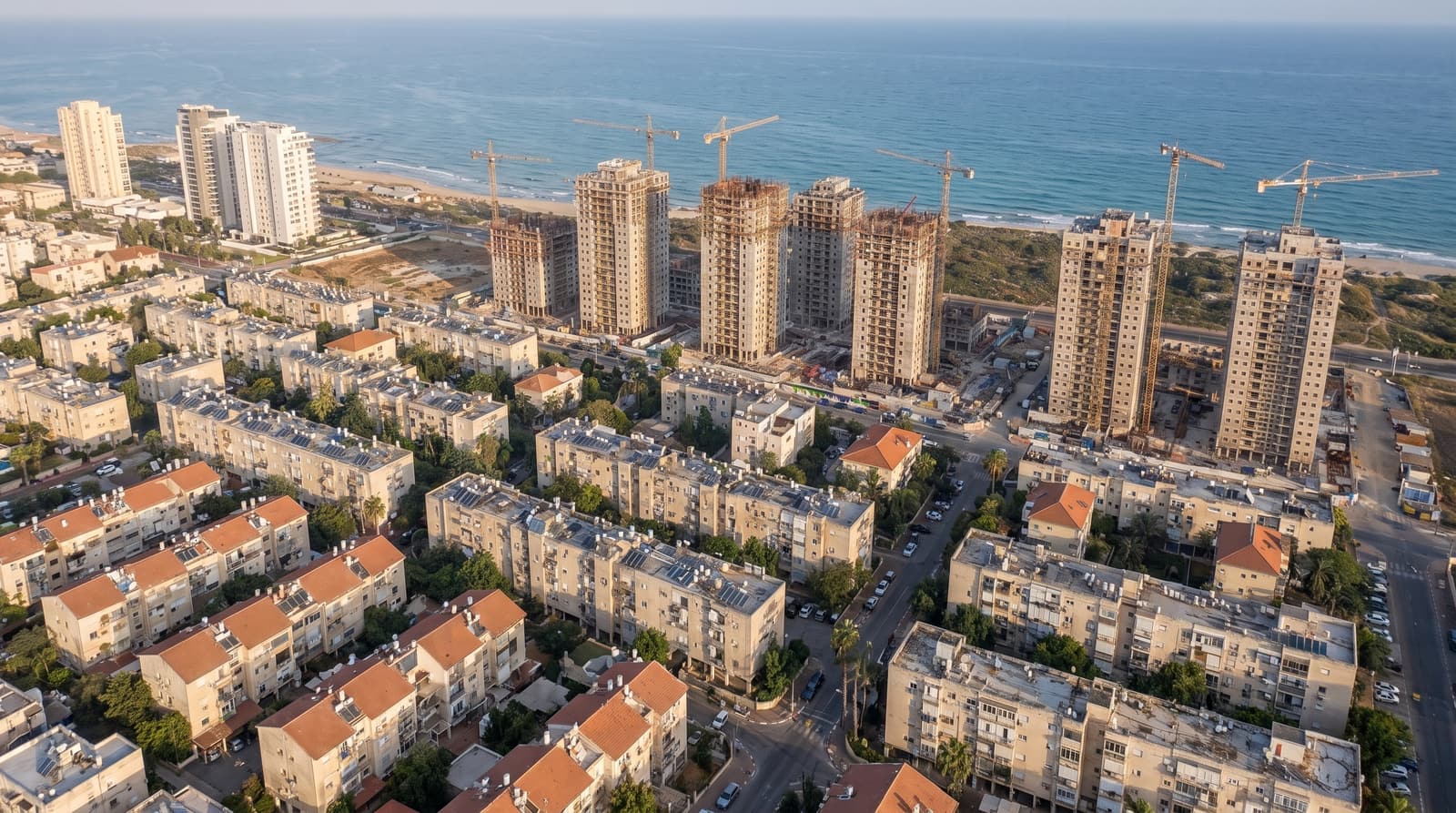 Une rangée d’immeubles anciens de quelques étages et, derrière eux, de nouvelles tours d’habitation qui s’élèvent au bord de la mer
